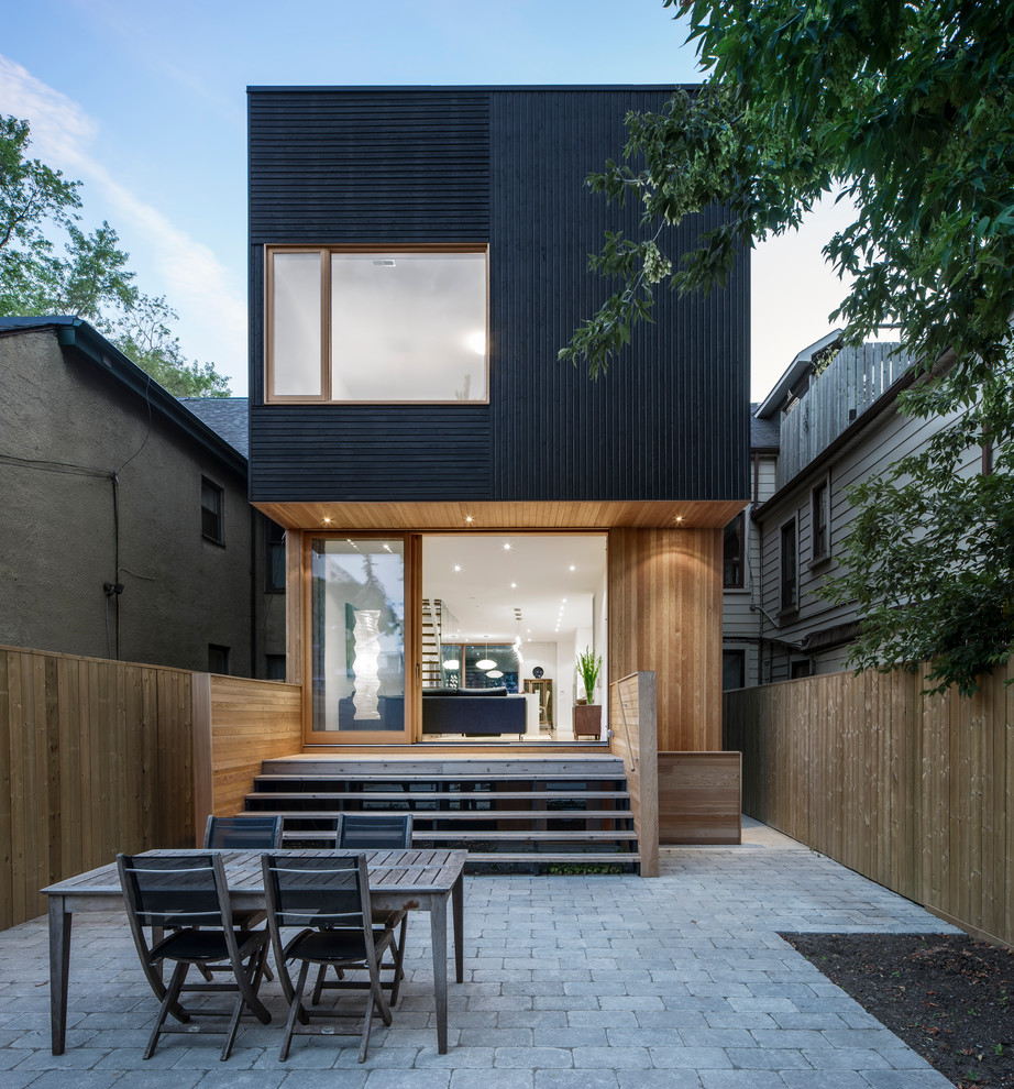 Modelo de fachada negra minimalista de tamaño medio de tres plantas con revestimiento de madera
