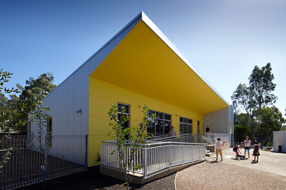 Свежая идея для дизайна: одноэтажный, желтый дом в современном стиле с облицовкой из металла - отличное фото интерьера