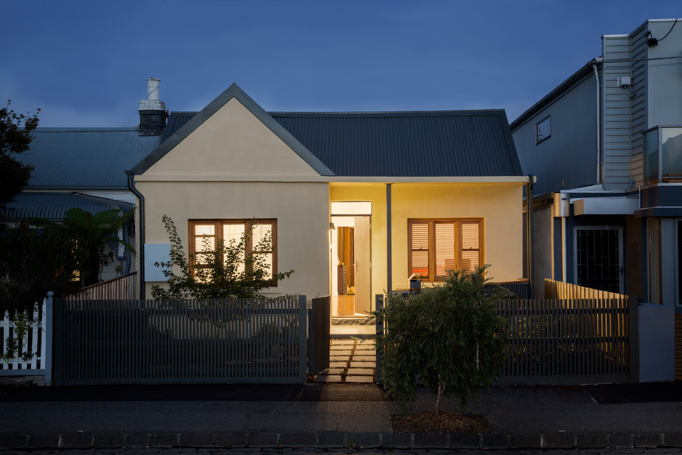 Idée de décoration pour une petite façade de maison beige design de plain-pied avec un toit à deux pans.