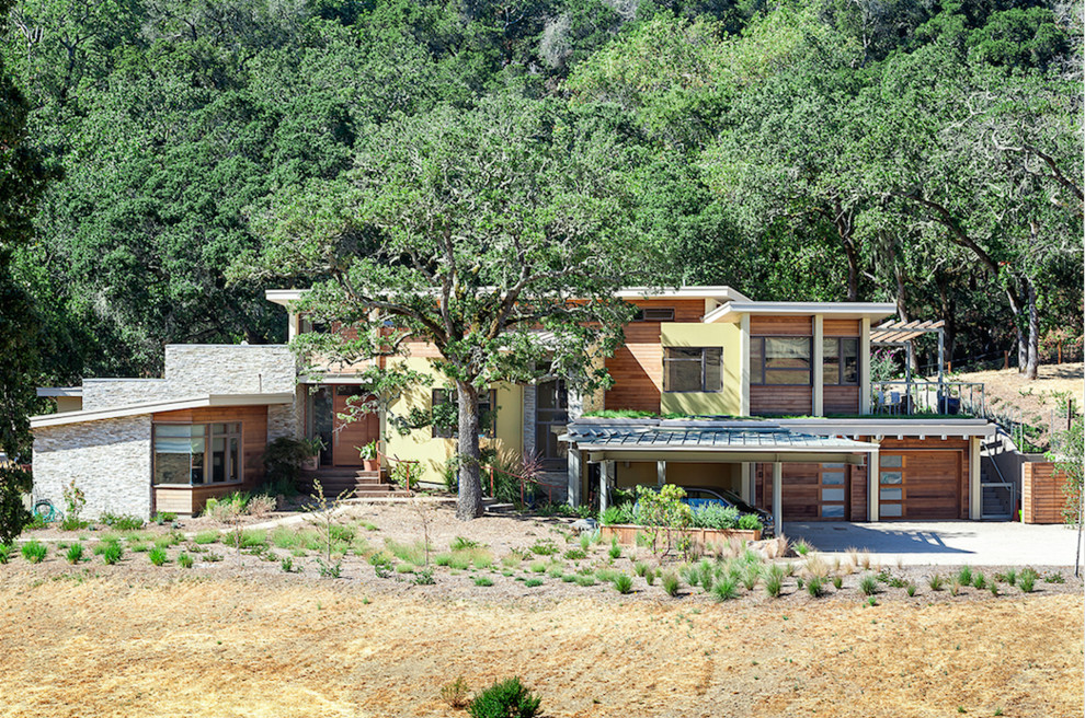 Ejemplo de fachada de casa marrón y gris moderna grande de dos plantas con tejado plano y tejado de metal