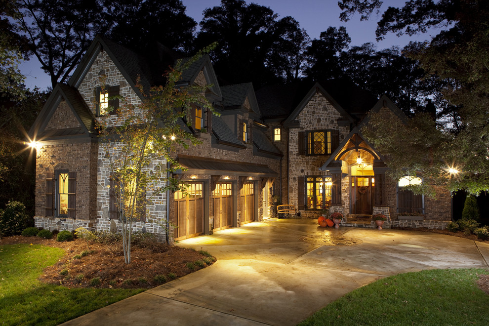 Example of a large mountain style beige two-story stone exterior home design in Atlanta with a hip roof
