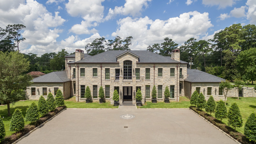 Inspiration for an expansive and gey traditional two floor house exterior in Houston with stone cladding.