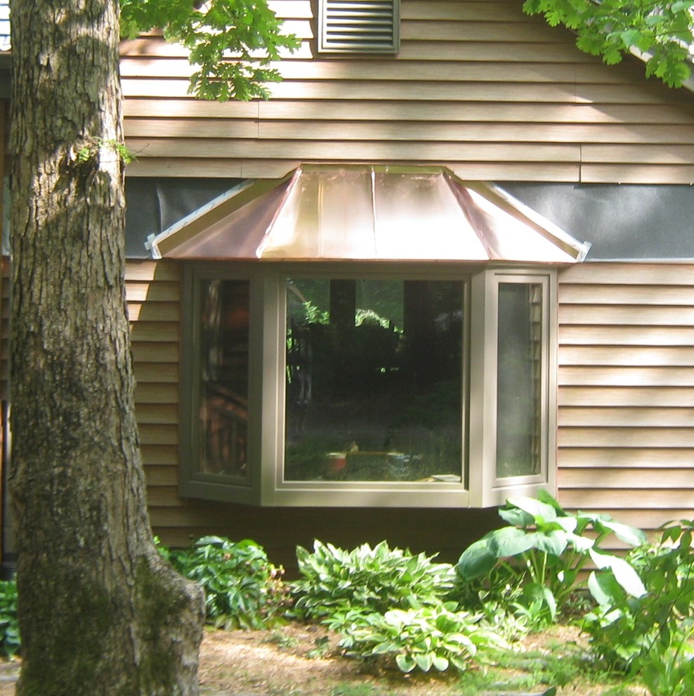 Пример оригинального дизайна: двухэтажный, бежевый дом среднего размера в стиле рустика с облицовкой из винила