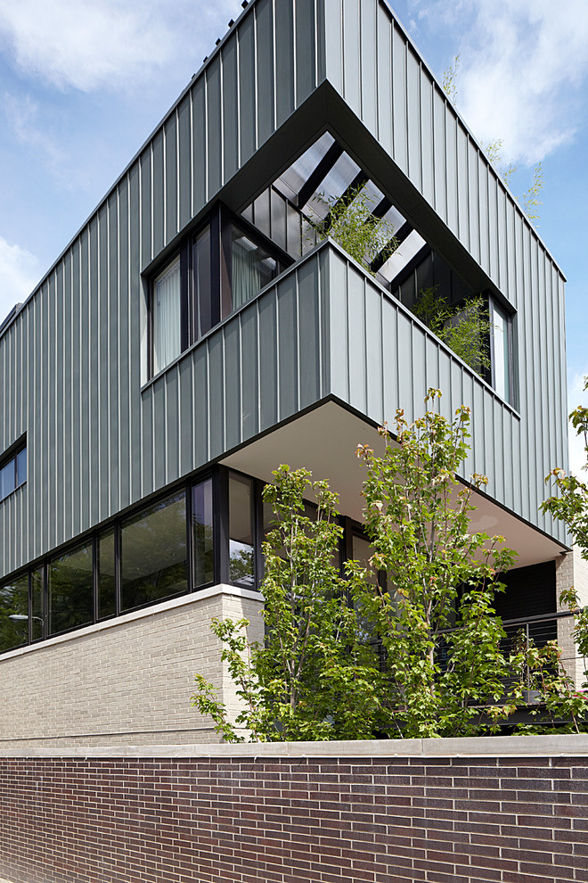 Exempel på ett stort modernt grått hus, med tre eller fler plan, metallfasad och platt tak