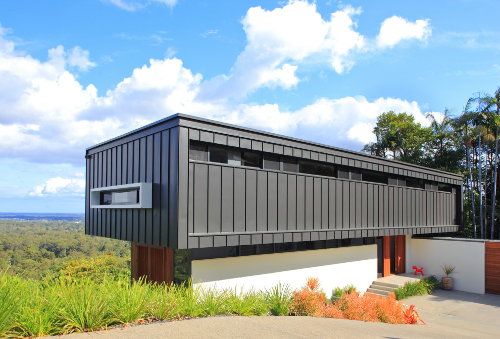 Imagen de fachada de casa gris contemporánea de dos plantas con revestimiento de metal, tejado plano y tejado de metal