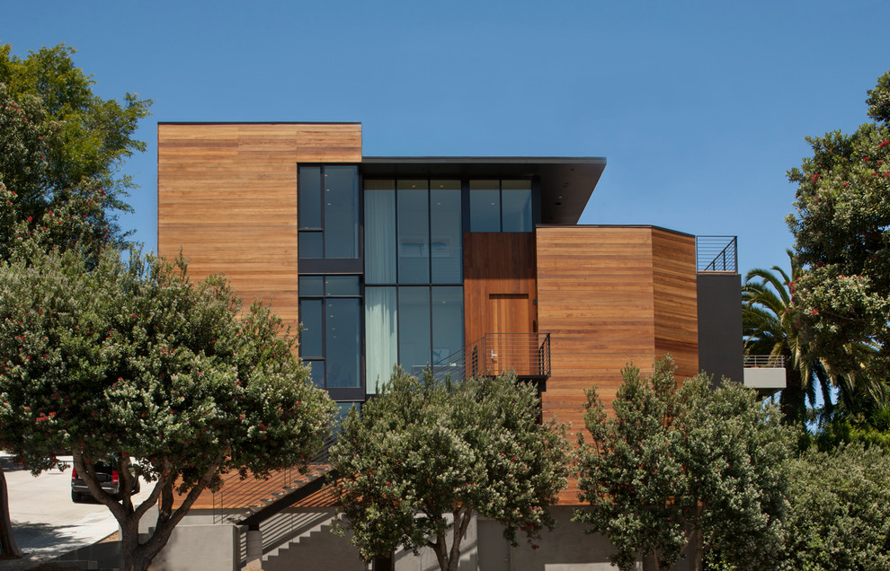 Ejemplo de fachada marrón moderna de tamaño medio de tres plantas con revestimiento de madera