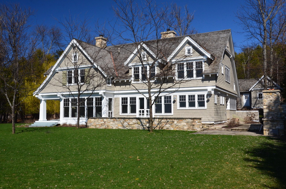 Foto de fachada de casa beige de estilo americano grande de dos plantas con revestimiento de madera, tejado a dos aguas y tejado de teja de barro