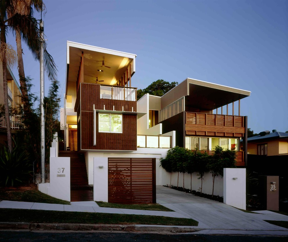Imagen de fachada de casa blanca moderna de tamaño medio de tres plantas con revestimiento de madera y tejado plano