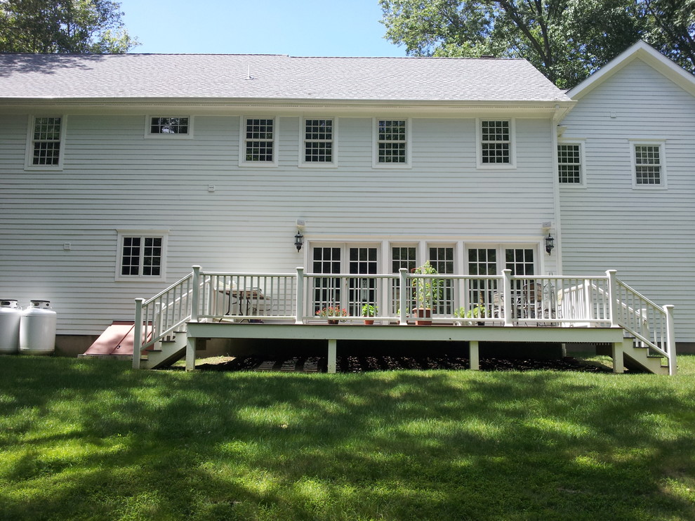 Imagen de fachada de casa blanca clásica de tamaño medio de dos plantas con revestimiento de madera, tejado a dos aguas y tejado de teja de madera