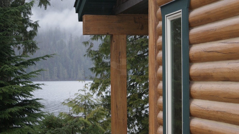 Idées déco pour une façade de maison marron montagne en béton à un étage avec un toit à deux pans.