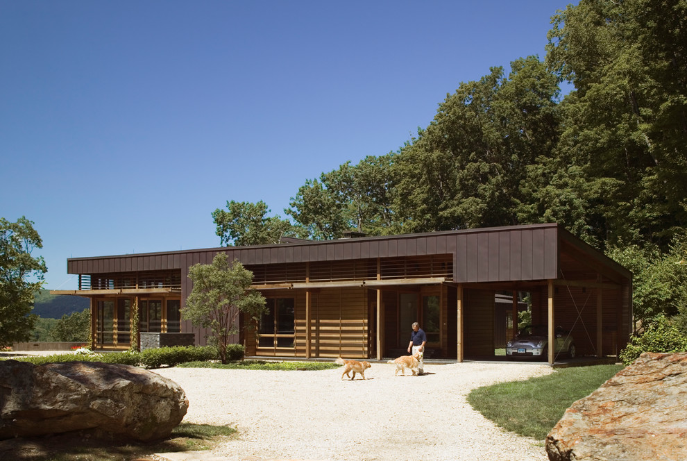 На фото: деревянный, двухэтажный, коричневый дом среднего размера в стиле ретро с плоской крышей с