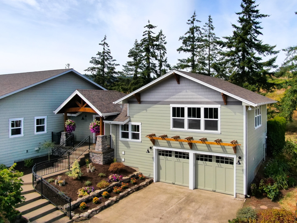 他の地域にある高級なカントリー風のおしゃれな家の外観 (コンクリート繊維板サイディング、緑の外壁) の写真