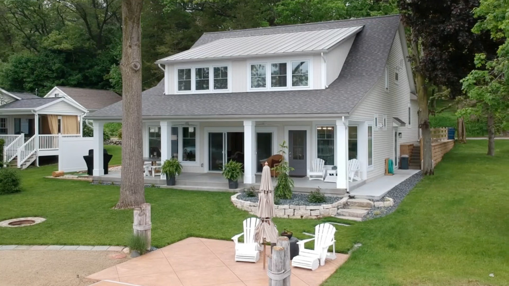 Inspiration pour une façade de maison beige rustique de taille moyenne et à niveaux décalés avec un revêtement en vinyle, un toit à deux pans et un toit mixte.