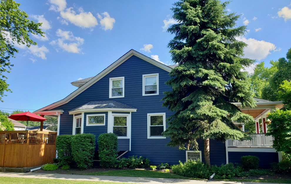Diseño de fachada de casa azul de estilo americano de tamaño medio de dos plantas con revestimiento de aglomerado de cemento, tejado a dos aguas y tejado de teja de madera