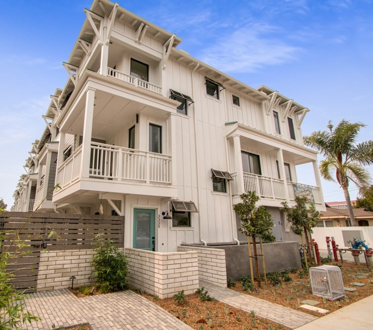 Foto della facciata di un appartamento bianco stile marinaro a tre piani di medie dimensioni con rivestimento con lastre in cemento e pannelli e listelle di legno