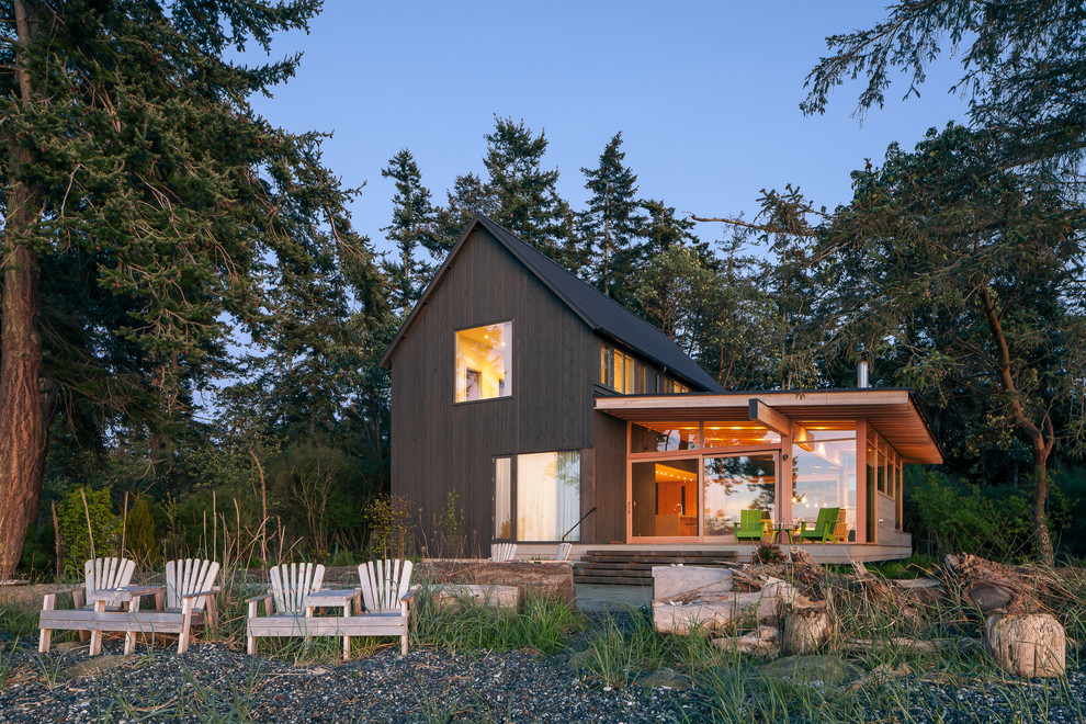 Brown beach style two floor house exterior in Seattle with wood cladding and a pitched roof.