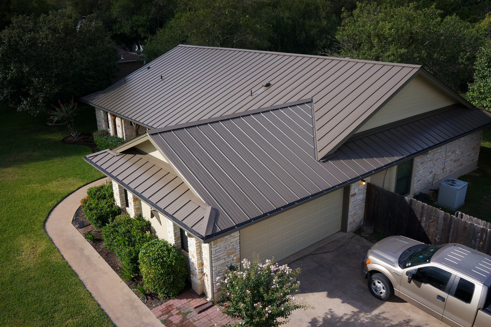 Example of a large classic beige one-story mixed siding exterior home design in Austin with a metal roof