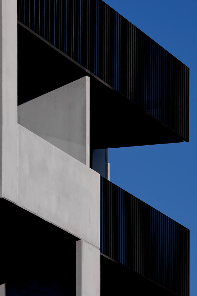 Großes, Dreistöckiges Modernes Wohnung mit Betonfassade und grauer Fassadenfarbe in Sonstige