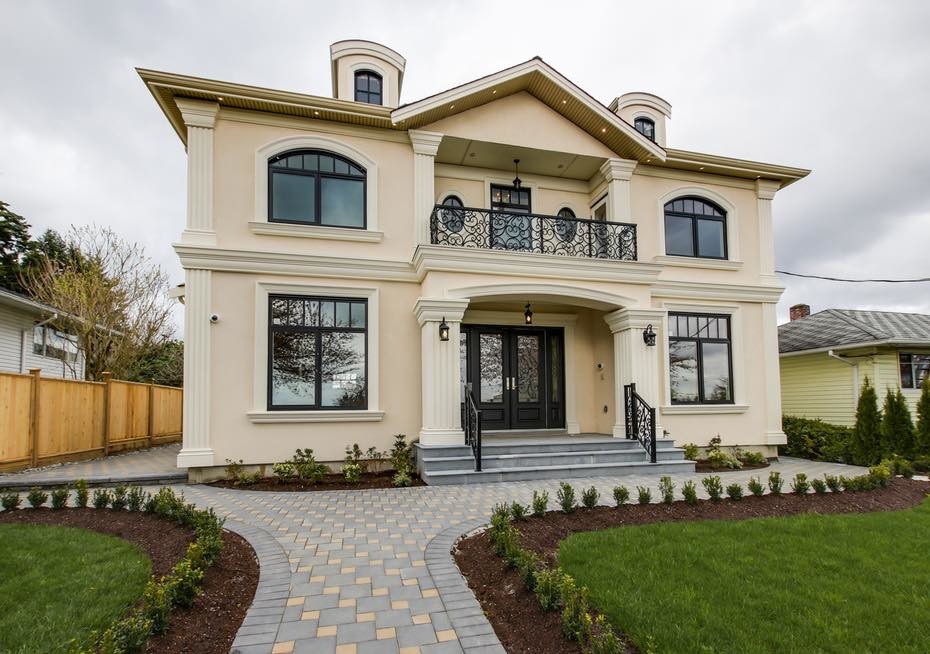 Inspiration for a large mediterranean beige two-story stucco gable roof remodel in Vancouver