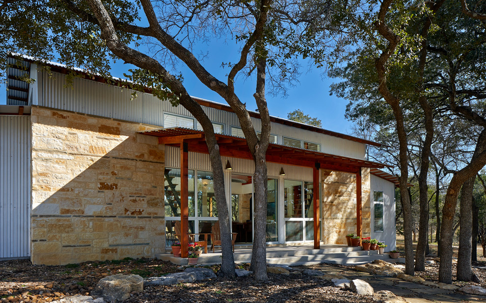Inspiration for a small contemporary one-story stone gable roof remodel in Austin
