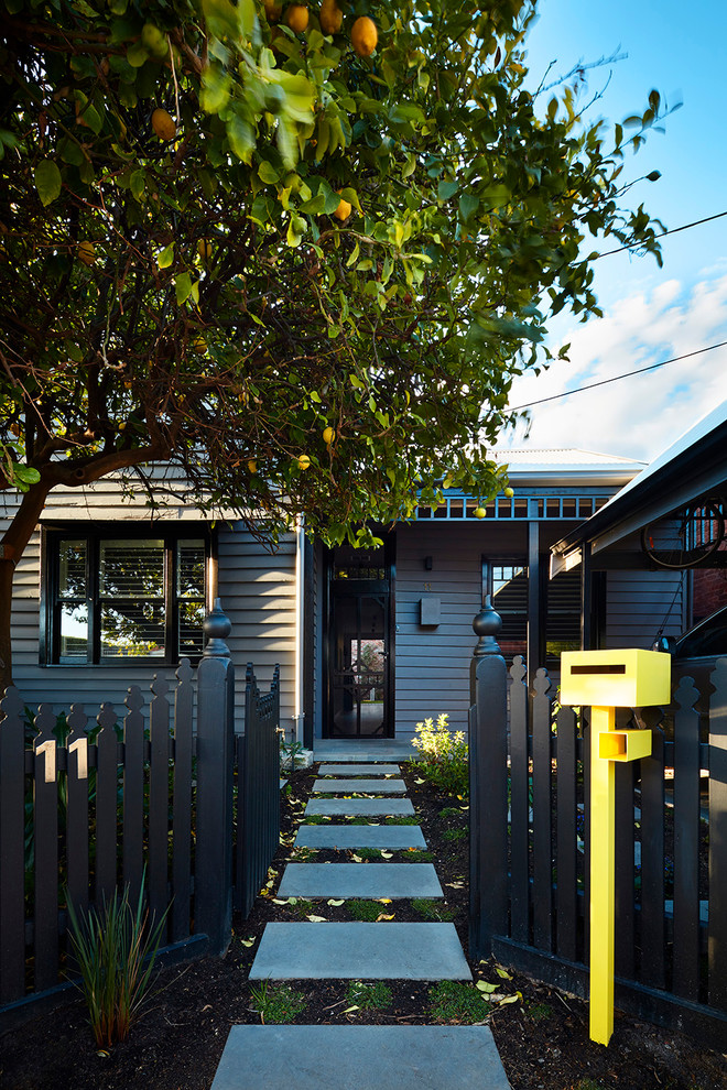 Inspiration för ett litet funkis grått hus, med två våningar, sadeltak och tak i metall