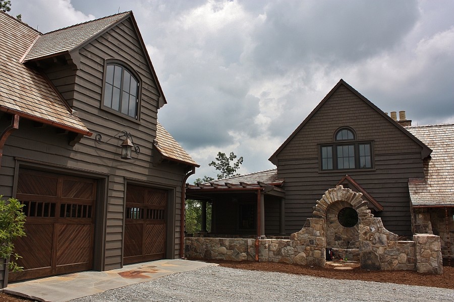 Foto de fachada marrón de estilo de casa de campo extra grande de dos plantas con revestimiento de madera y tejado a dos aguas