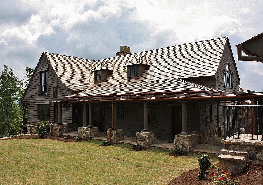 Foto della facciata di una casa ampia verde country a due piani con rivestimento in legno e tetto a capanna