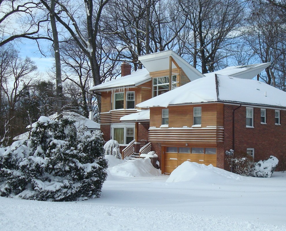 Photo of a medium sized modern split-level house exterior in New York with wood cladding and a hip roof.
