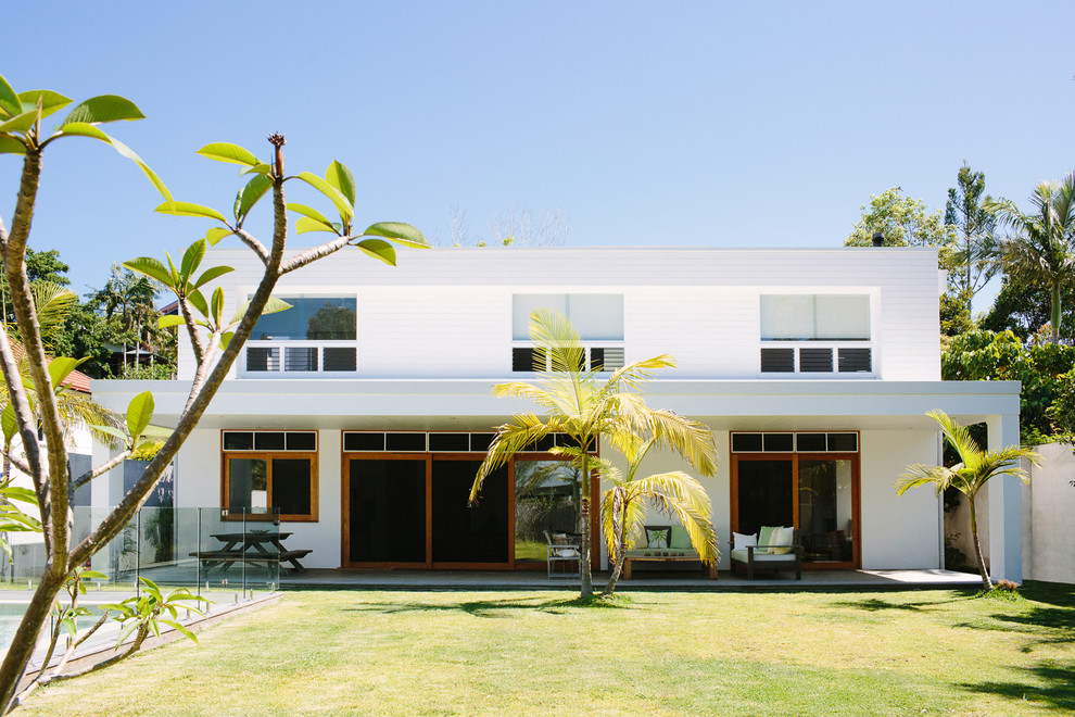Imagen de fachada de casa blanca actual de tamaño medio de dos plantas con revestimiento de madera y tejado plano