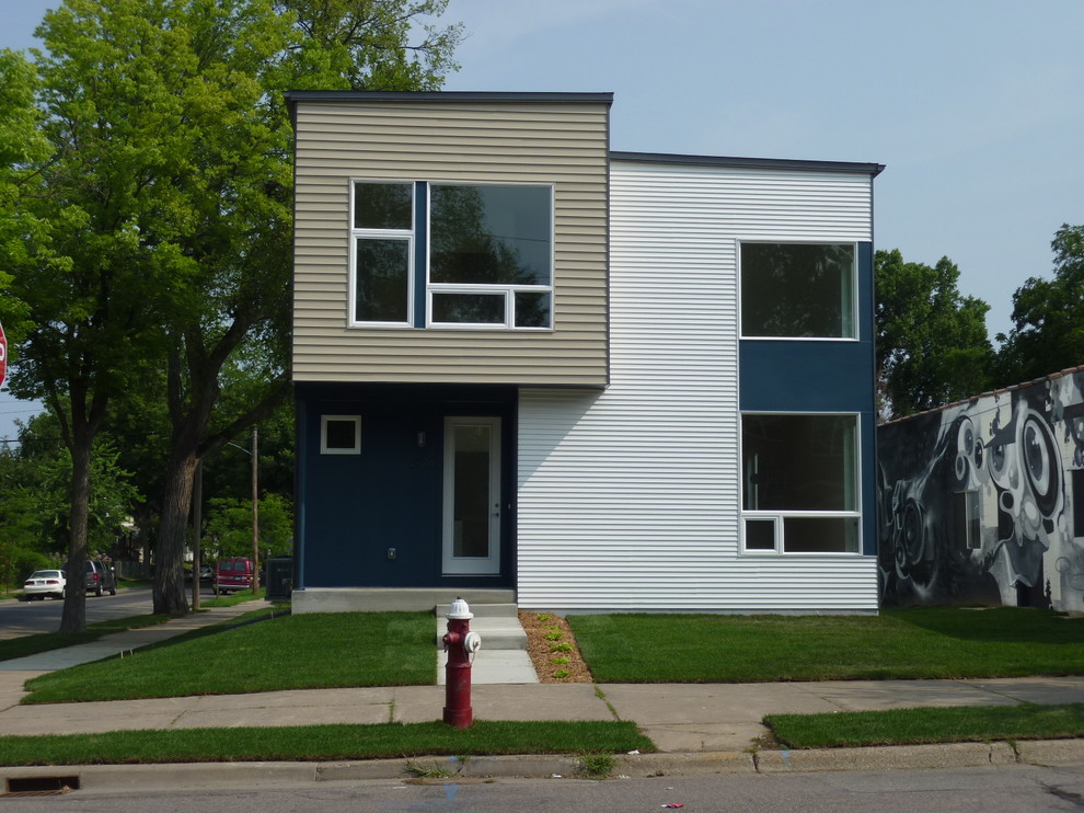 Foto della facciata di una casa blu moderna a due piani con rivestimenti misti