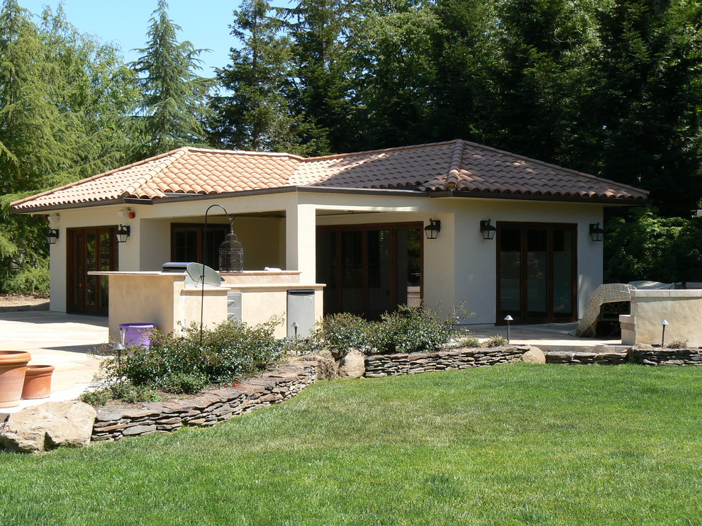 Idee per la facciata di una casa piccola beige mediterranea a un piano con rivestimento in stucco e tetto a padiglione