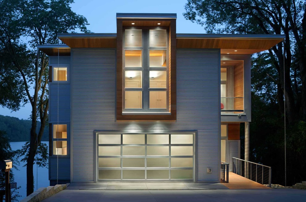 Imagen de fachada de casa blanca moderna de tamaño medio de dos plantas con revestimiento de metal y tejado plano