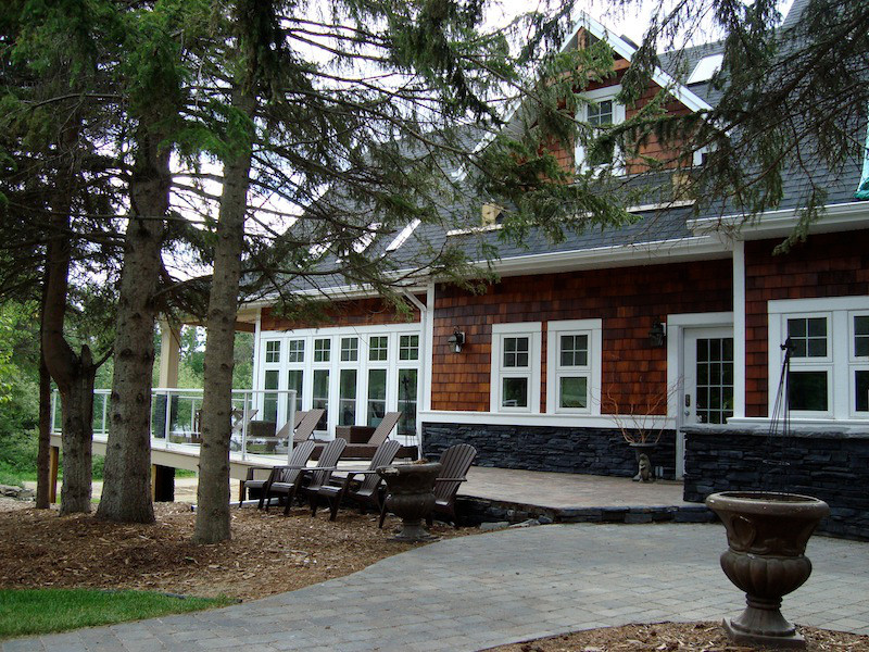 Пример оригинального дизайна: двухэтажный, коричневый дом в стиле кантри с комбинированной облицовкой