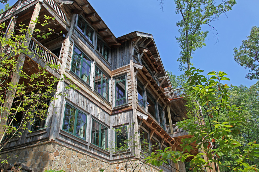 Esempio della facciata di una casa grande grigia rustica a due piani con rivestimenti misti