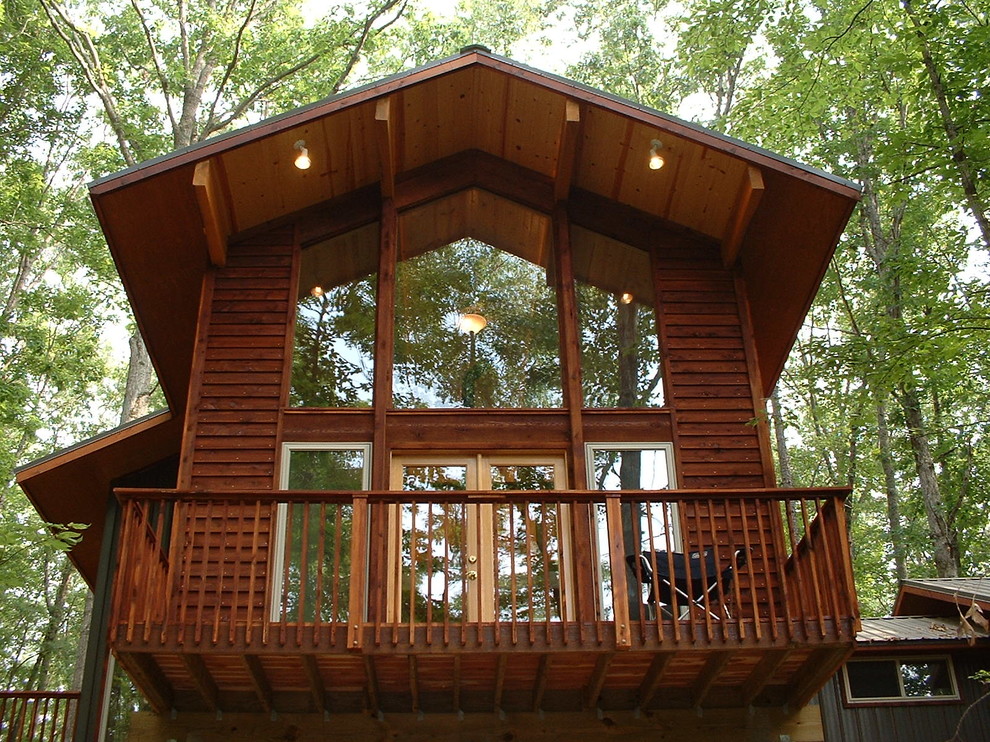 Aménagement d'une grande façade de maison marron montagne en bois à un étage avec un toit à croupette.
