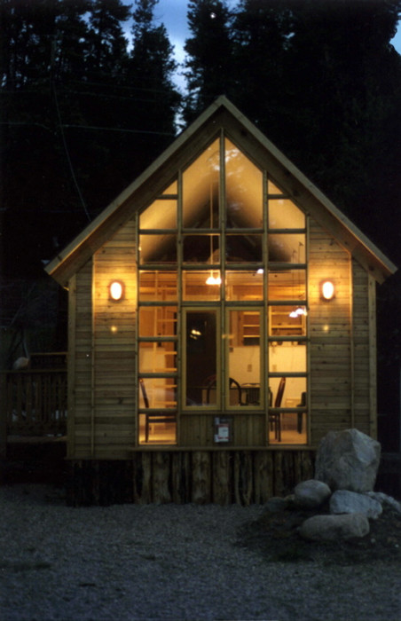 Foto della facciata di una casa marrone contemporanea a un piano con rivestimento in legno e tetto a capanna