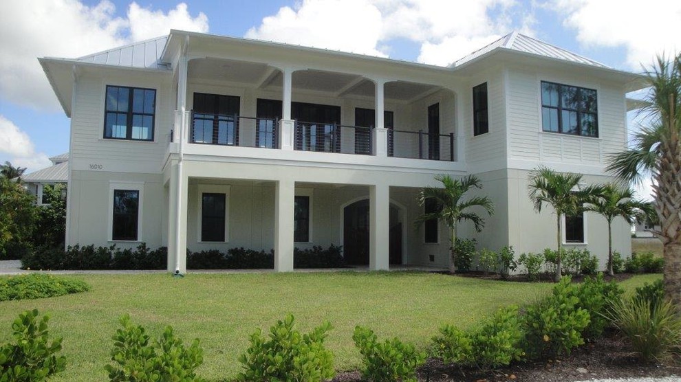 Idee per la villa grande bianca stile marinaro a due piani con rivestimento in legno, tetto a padiglione e copertura in metallo o lamiera