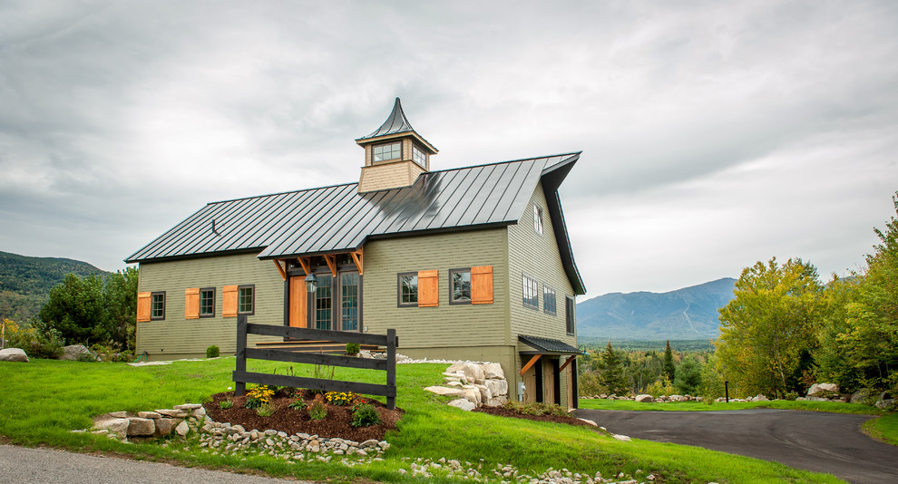Cette photo montre une façade de maison verte éclectique en bois de taille moyenne et à un étage avec un toit à deux pans.