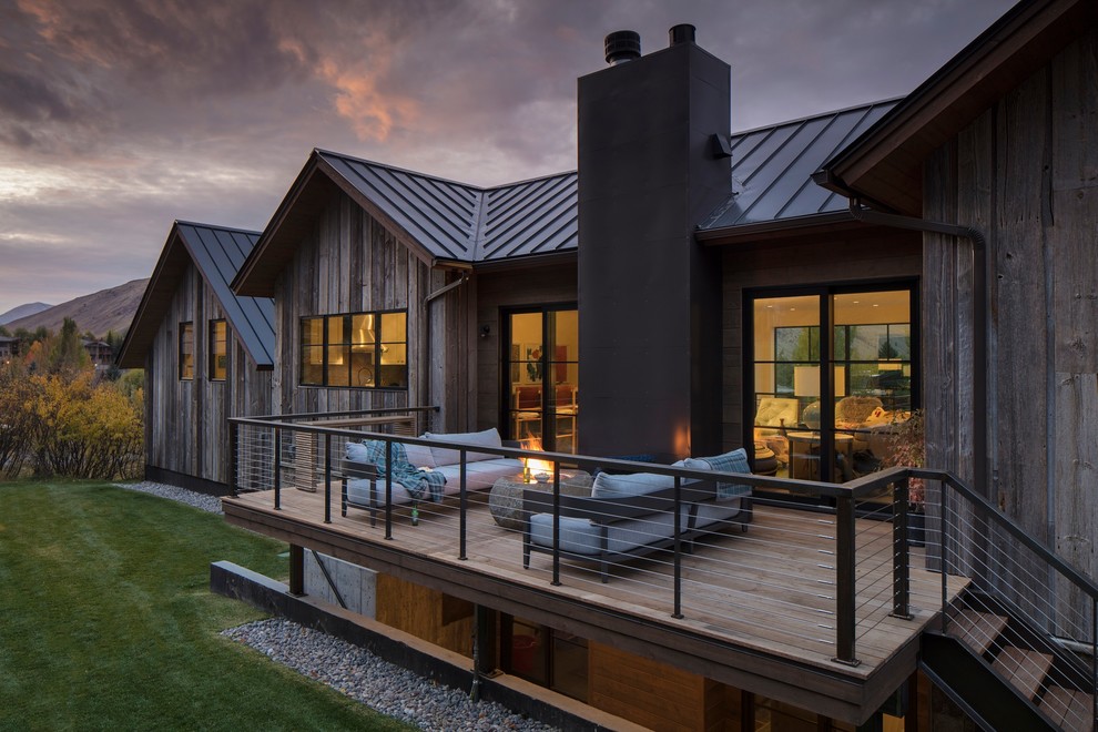 Diseño de fachada de casa gris contemporánea grande de dos plantas con revestimientos combinados, tejado a dos aguas y tejado de metal