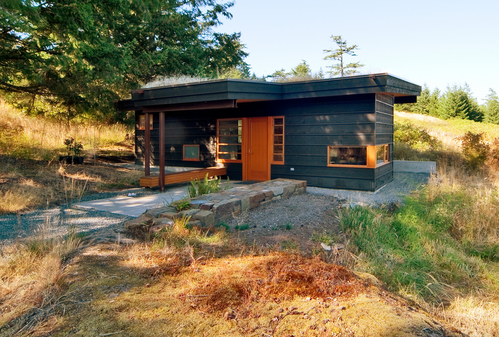 Cette photo montre une petite façade de maison grise moderne de plain-pied avec un revêtement mixte et un toit plat.