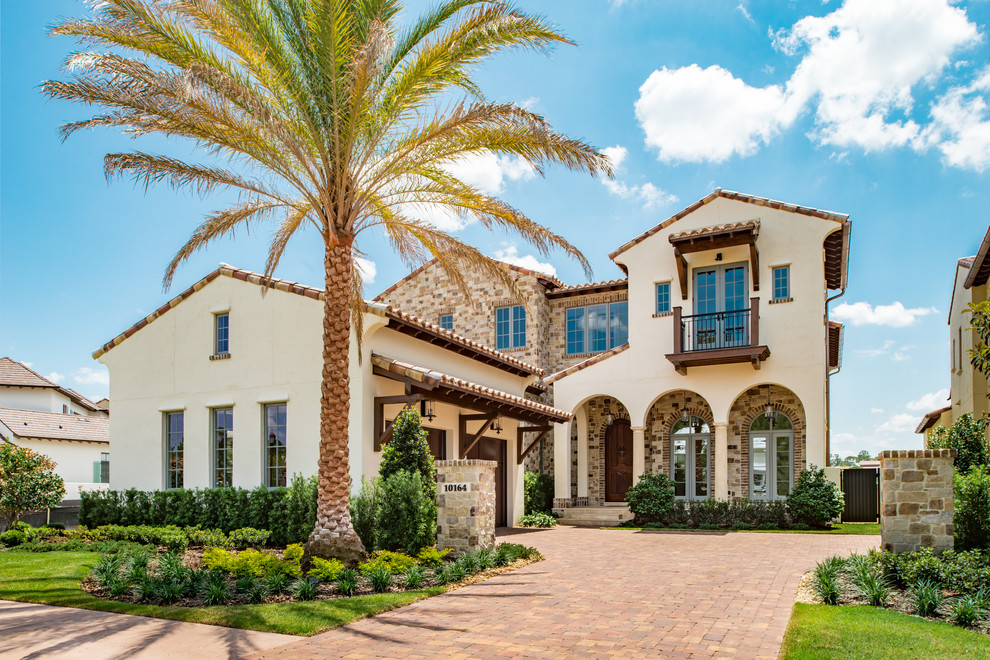 Inspiration for a mediterranean beige two-story exterior home remodel in Orlando with a tile roof