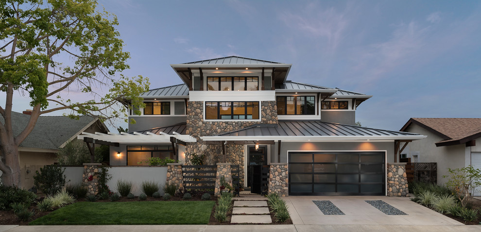 Aménagement d'une façade de maison grise craftsman de taille moyenne et à un étage avec un toit à quatre pans et un toit en métal.