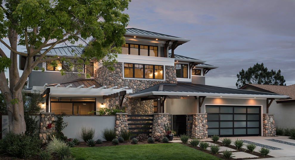 Imagen de fachada de casa gris de estilo americano de tamaño medio de dos plantas con tejado a cuatro aguas y tejado de metal