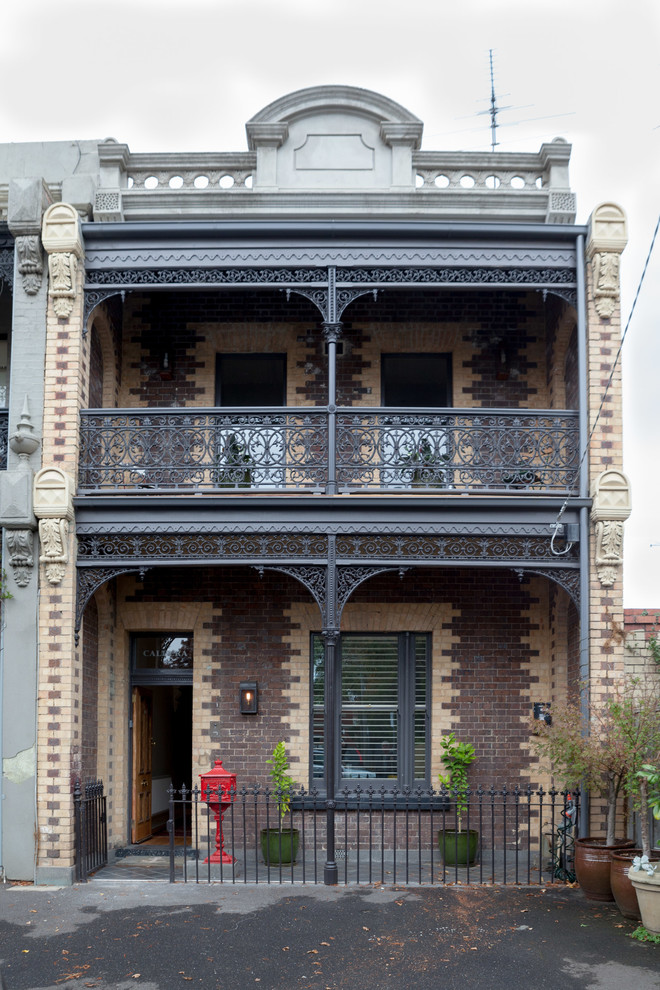 На фото: большой, трехэтажный, кирпичный, коричневый дом в викторианском стиле с