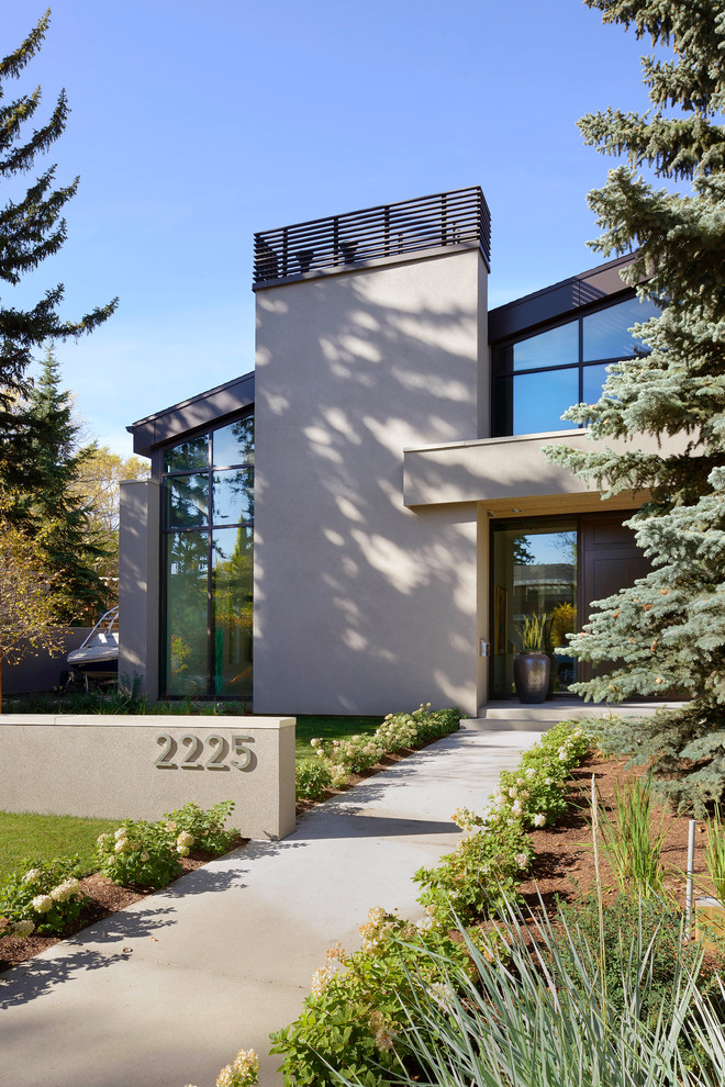 Zweistöckiges, Mittelgroßes Modernes Einfamilienhaus mit beiger Fassadenfarbe, Betonfassade und Pultdach in Calgary