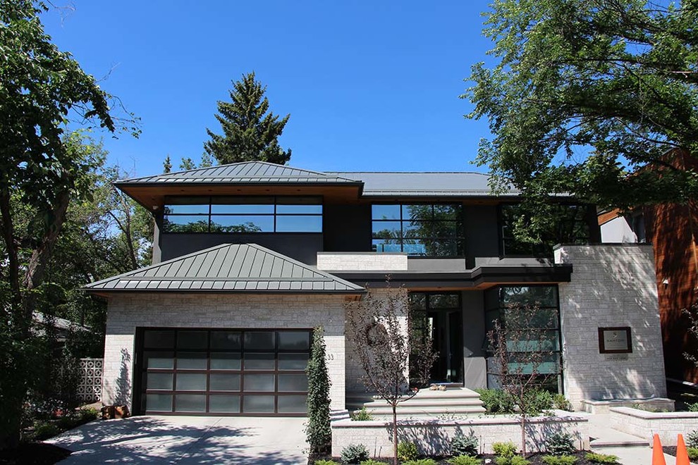 Aménagement d'une grande façade de maison grise moderne à un étage avec un revêtement mixte, un toit en métal et un toit à quatre pans.
