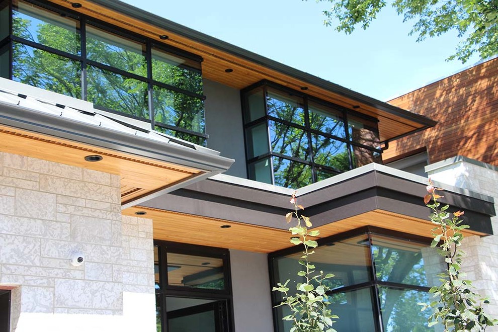 Exemple d'une grande façade de maison grise moderne à un étage avec un revêtement mixte, un toit en métal et un toit à quatre pans.