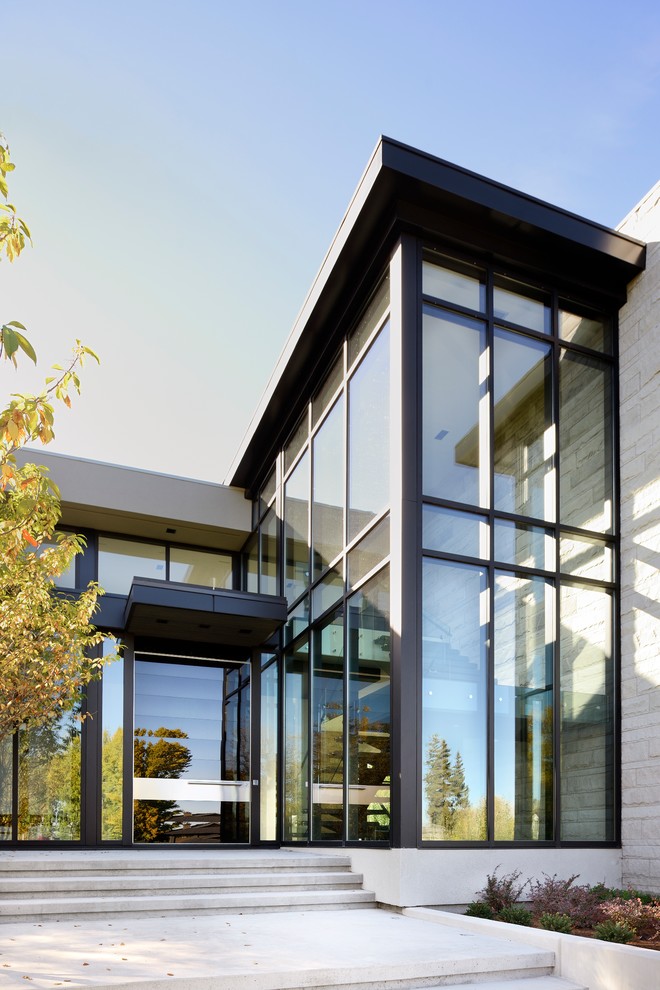 Foto de fachada de casa beige moderna grande de dos plantas con tejado plano y revestimientos combinados
