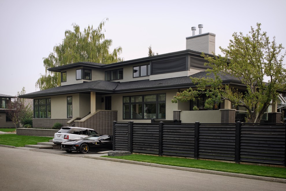Inspiration for a medium sized and beige contemporary two floor detached house in Calgary with mixed cladding, a hip roof and a shingle roof.