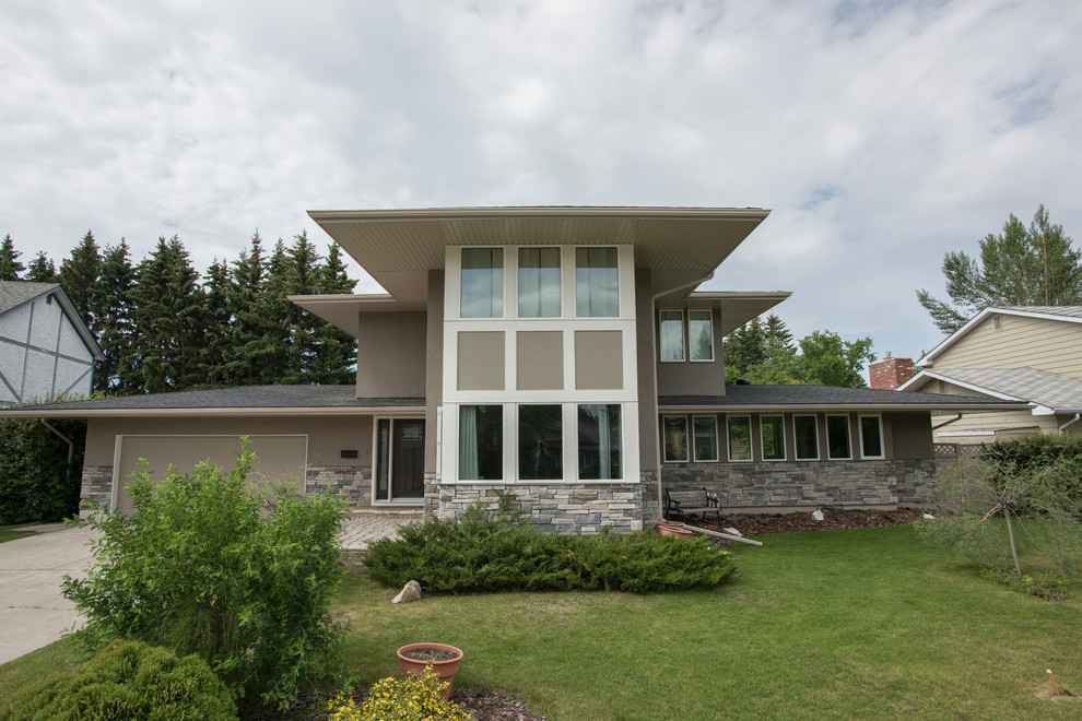 Großes, Zweistöckiges Modernes Einfamilienhaus mit Putzfassade, beiger Fassadenfarbe, Flachdach und Schindeldach in Calgary